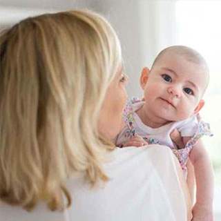 Baby overlooking mum's shoulder