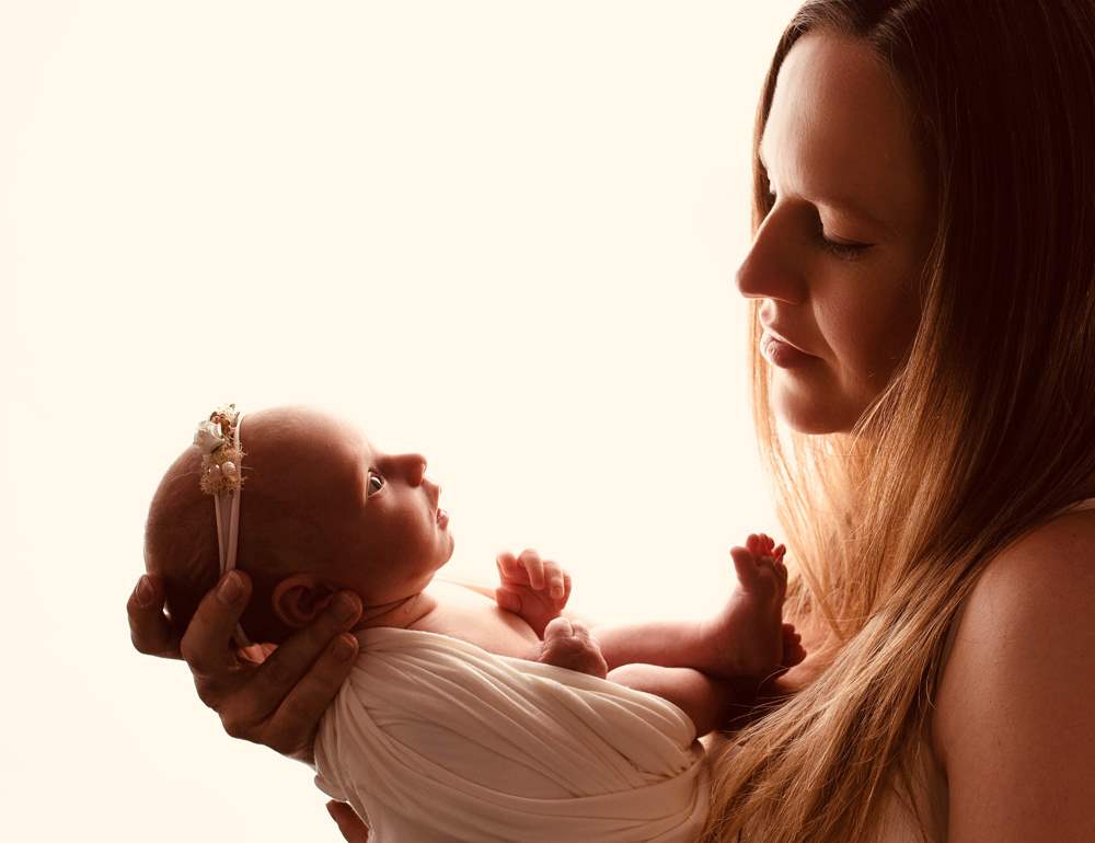 Mother holding and looking at newborn baby