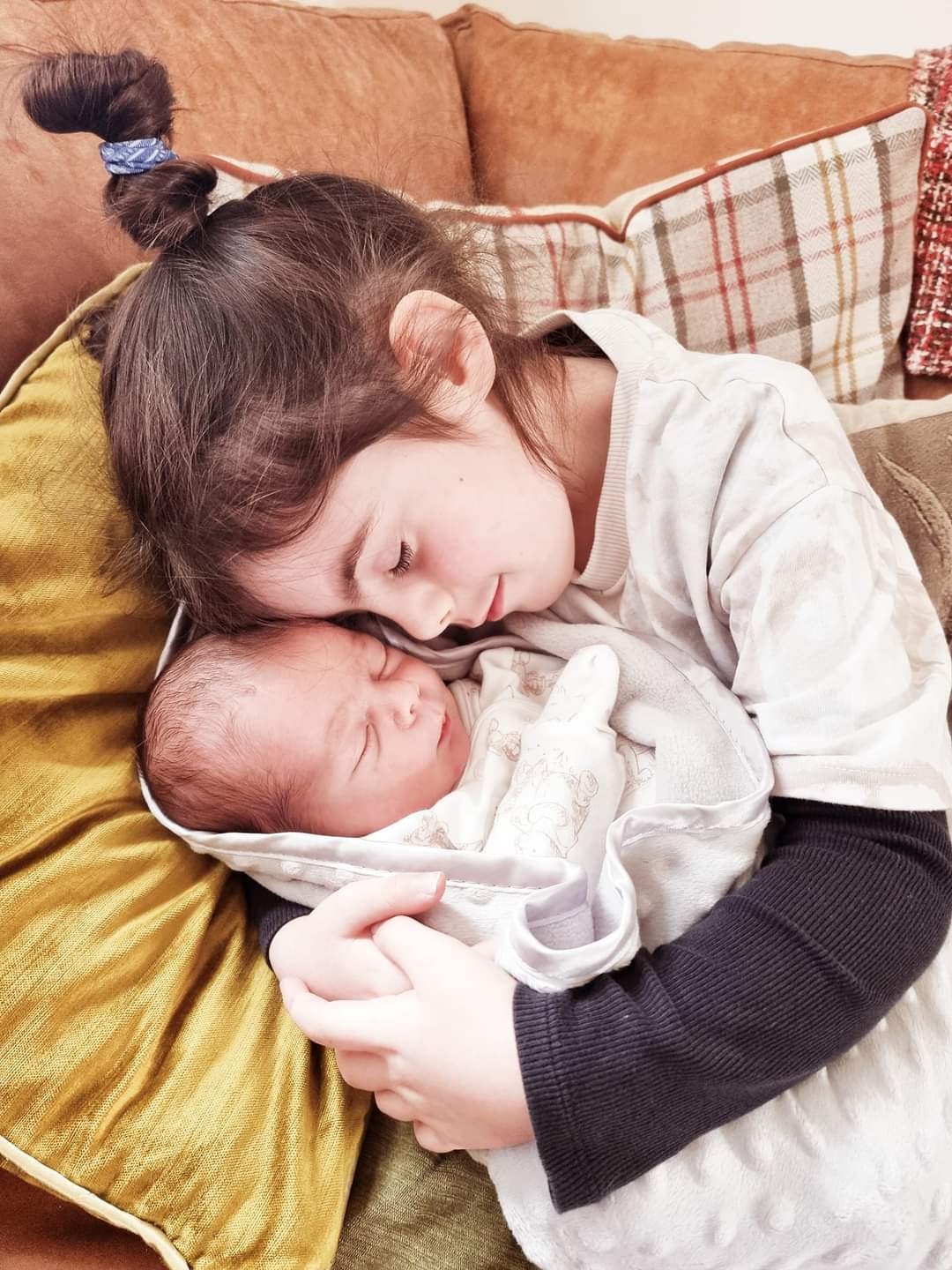 Sister holding newborn baby brother